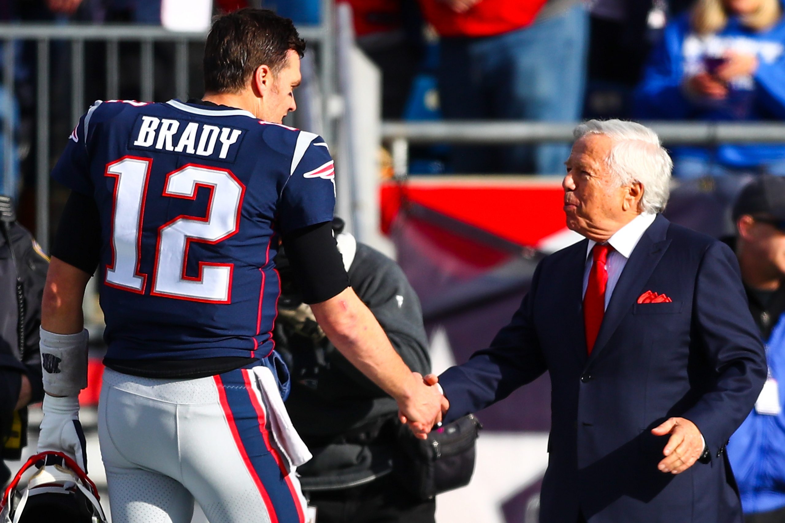 Tom Brady shakes the hand of owner Robert Kraft of the New England Patriots before a game against the Miami Dolphins.