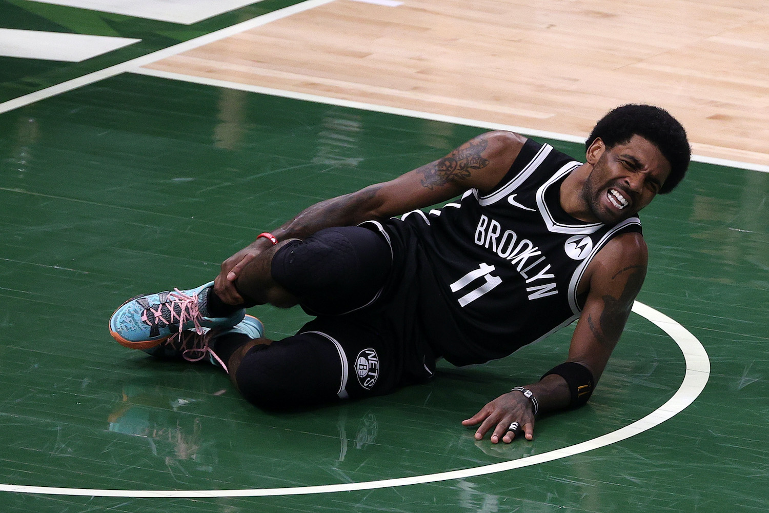 Brooklyn Nets guard Kyrie Irving goes down with an ankle injury against the Milwaukee Bucks.