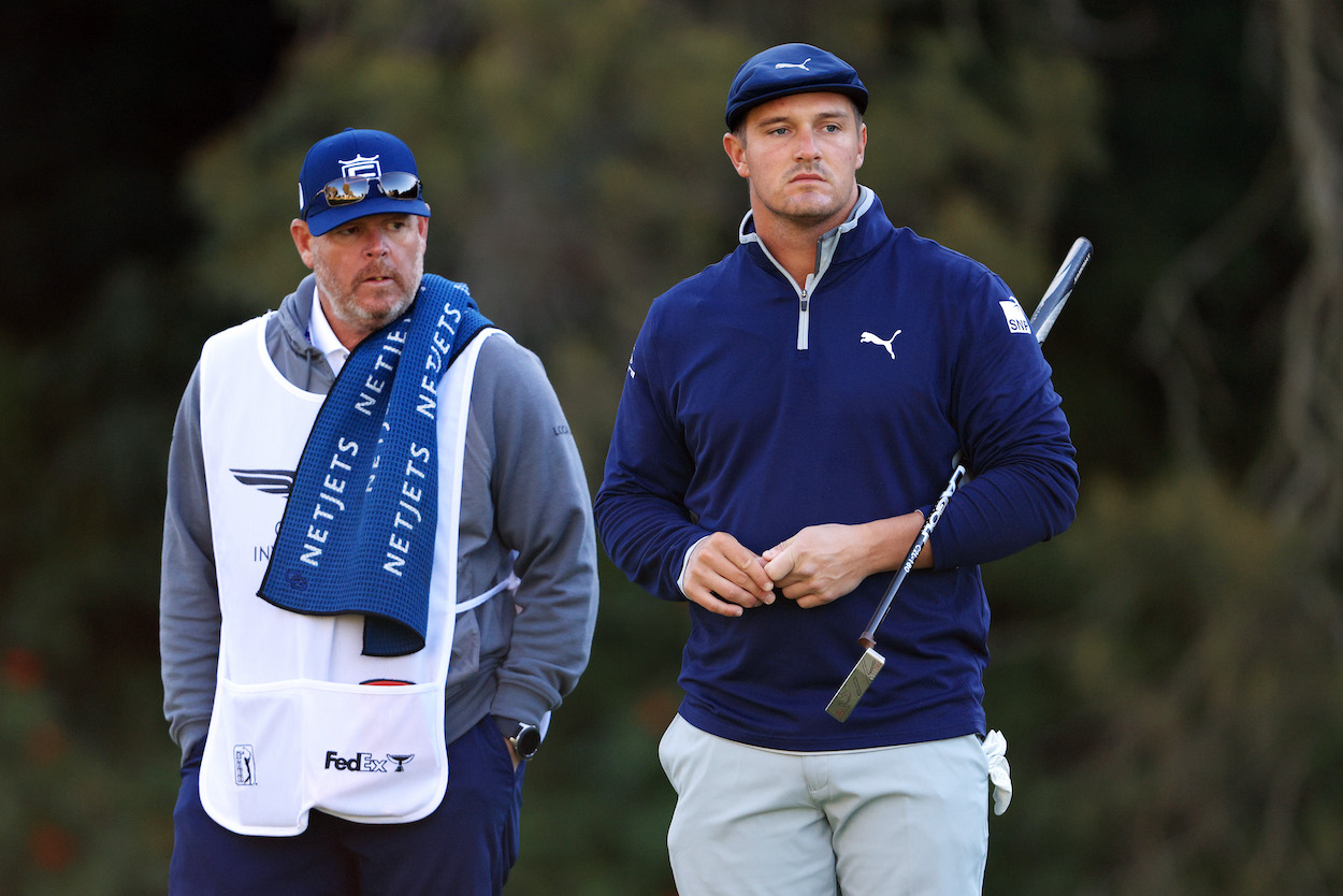 Bryson DeChambeau of the United States stands with his former caddie Tim Tucker on the 12th green during the second round of The Genesis Invitational at Riviera Country Club on February 19, 2021 in Pacific Palisades, California.