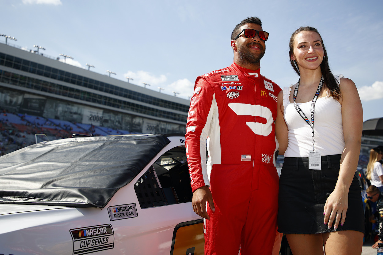 Bubba Wallace stands with girlfriend on grid
