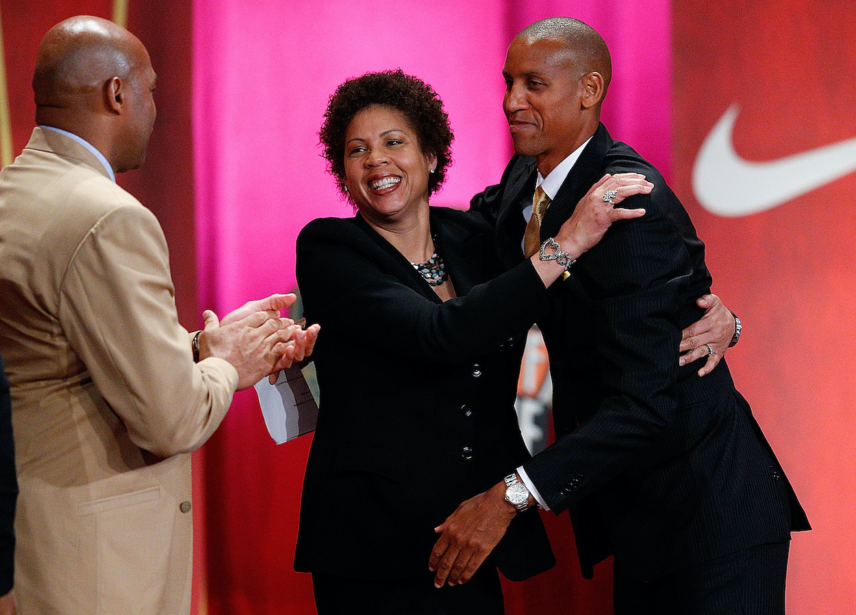 Reggie Miller is hugged by his sister Cheryl Miller as Charles Barkley applauds during the Basketball Hall of Fame Enshrinement Ceremony at Symphony Hall on September 7, 2012 in Springfield, Massachusetts.