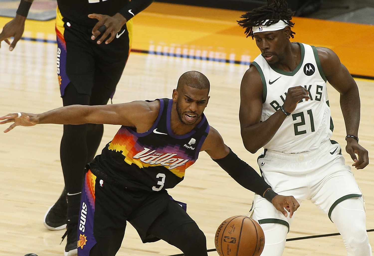 Chris Paul of the Phoenix Suns goes after a loose ball against Jrue Holiday of the Milwaukee Bucks during the first half in Game 2 of the NBA championship series.