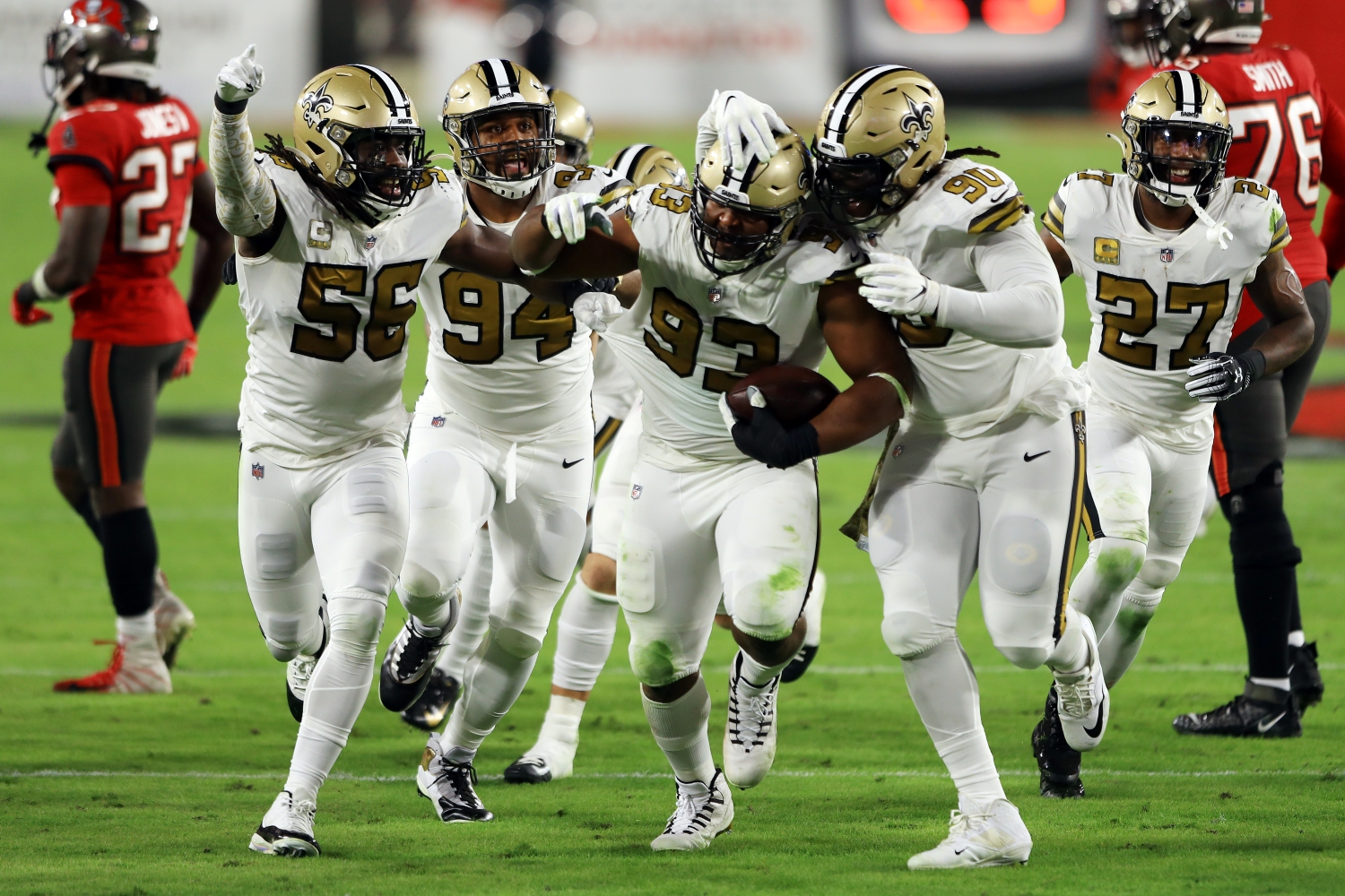 New Orleans Saints defensive tackle David Onyemata celebrates intercepting a pass with his teammates.