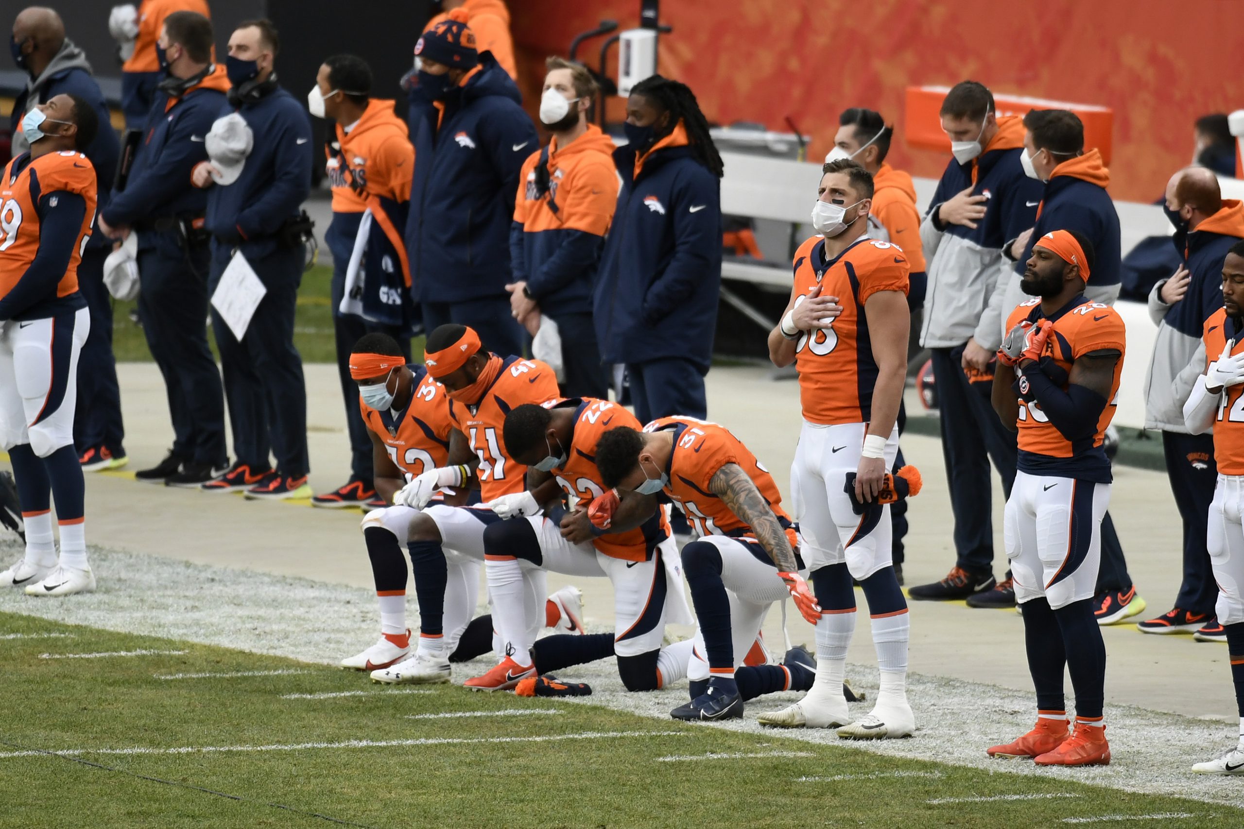 Denver Broncos Players take a moment of silence before the singing of the National Anthem in honor of former Denver Broncos halfback and hall of fame player Floyd Little before the start of the game at Empower Field at Mile High in January.