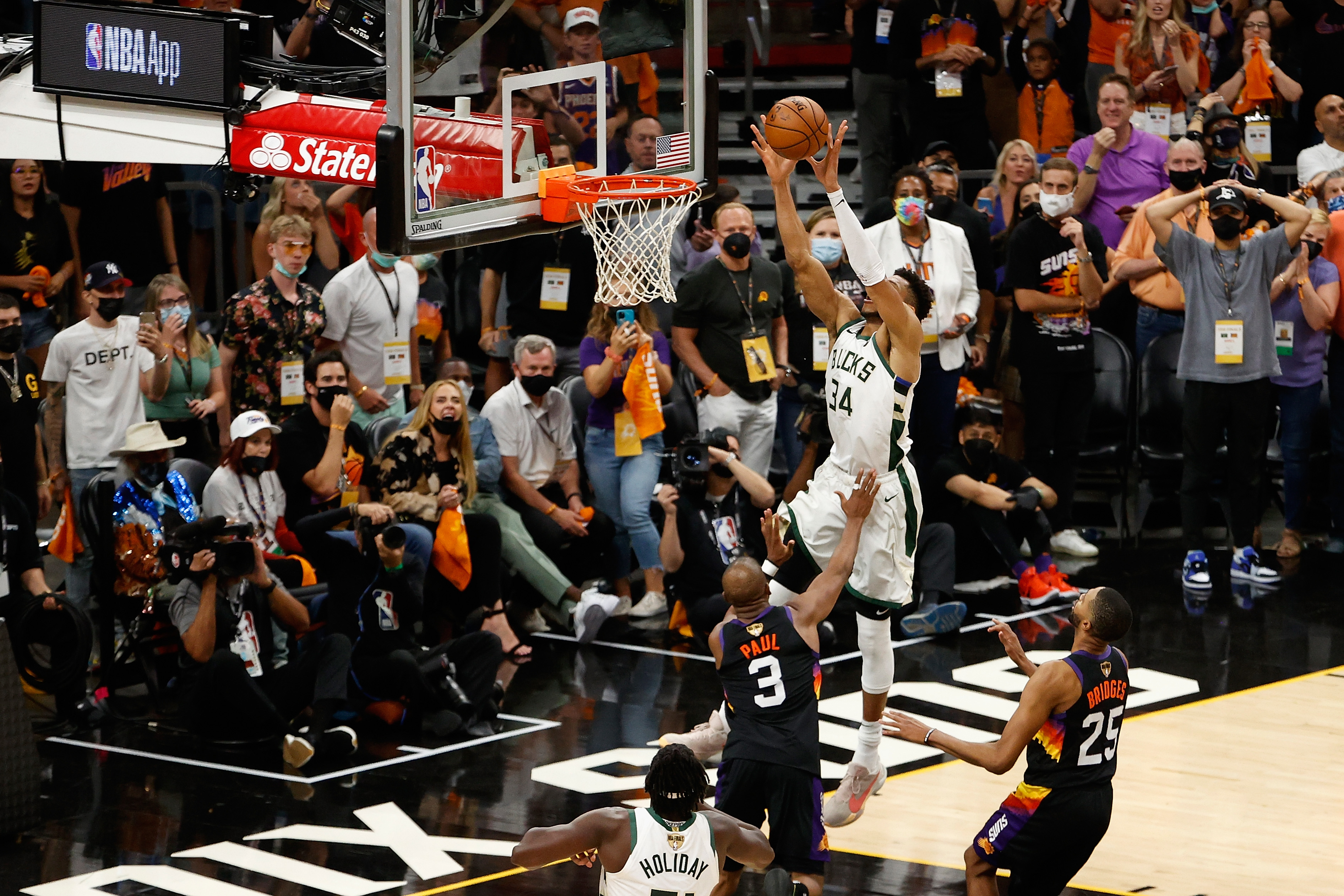 Milwaukee Bucks star Giannis Antetokounmpo dunks on Chris Paul during Game 5 of the NBA Finals.