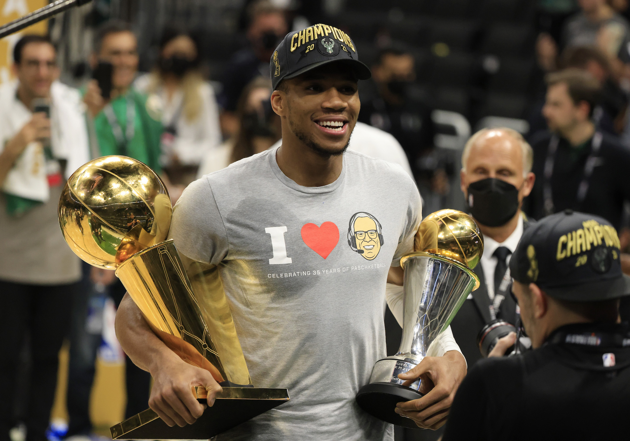 Milwaukee Bucks star Giannis Antetokounmpo holds the Larry O'Brien Trophy and Bill Russell Trophy after Game 6 of the NBA Finals