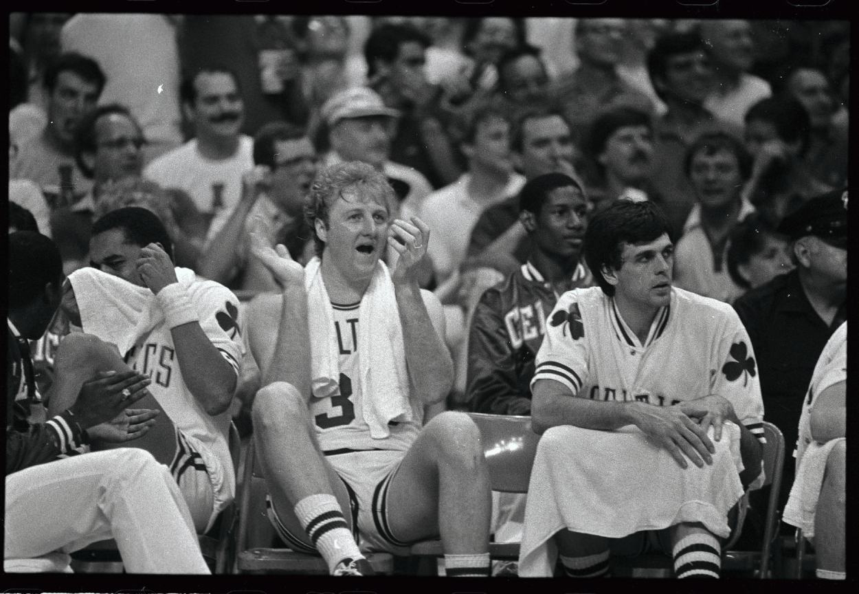Larry Bird applauds his teammates from the bench.
