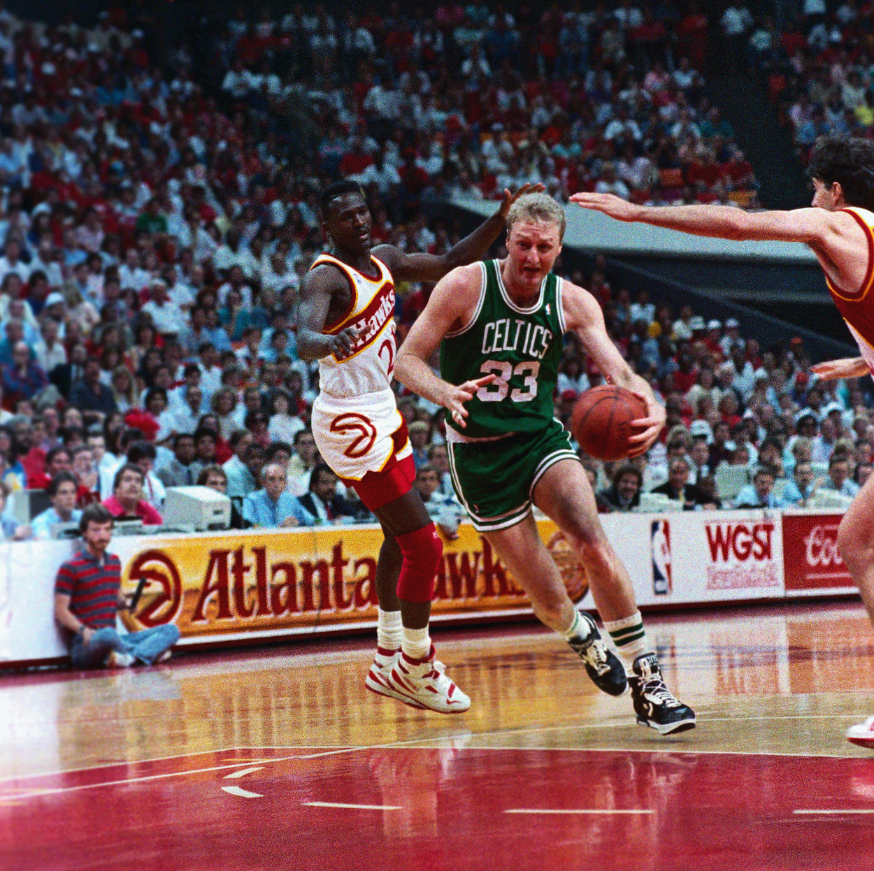 Celtics' forward Larry Bird goes to the basket over Hawks center Tree Rollins for two points during second period action.