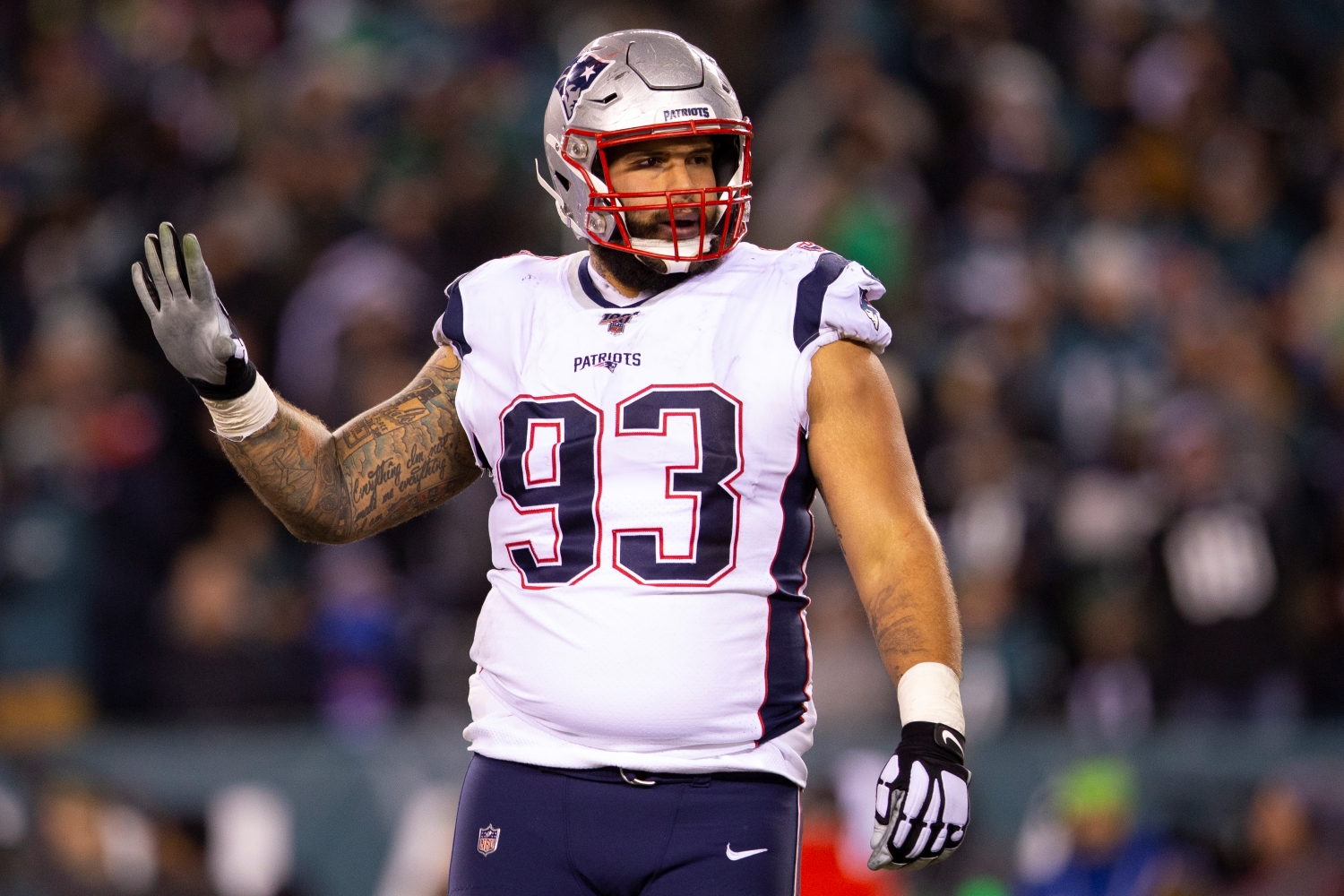 New England Patriots defensive lineman Lawrence Guy holds up four fingers while looking toward the sideline.