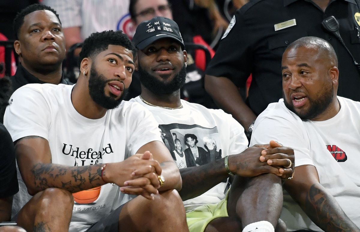 LeBron James sits courtside with teammate Anthony Davis.