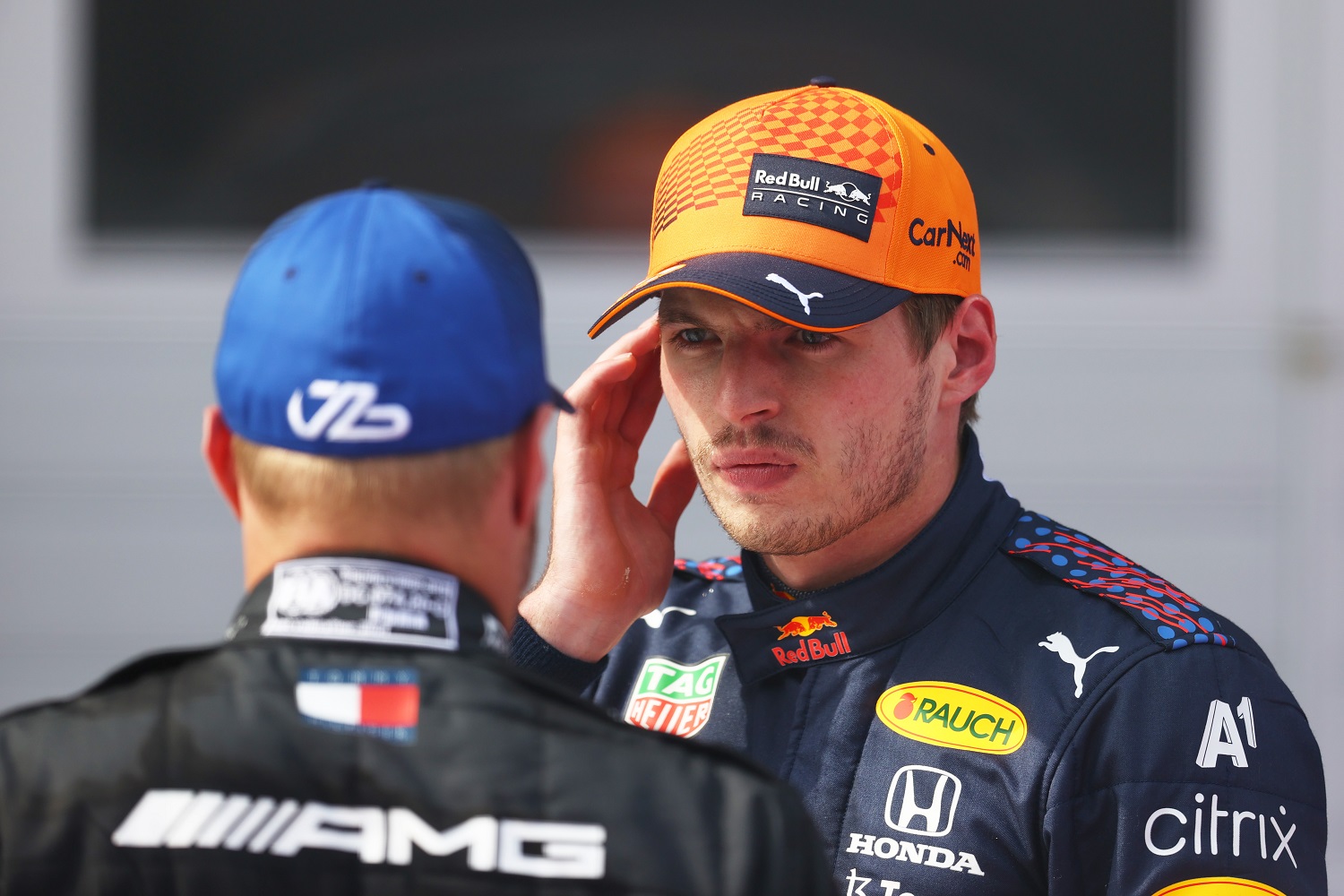 Race winner Max Verstappen of Red Bull Racing and second-place finisher Valtteri Bottas of Mercedes talk at the F1 Grand Prix of Austria at Red Bull Ring.