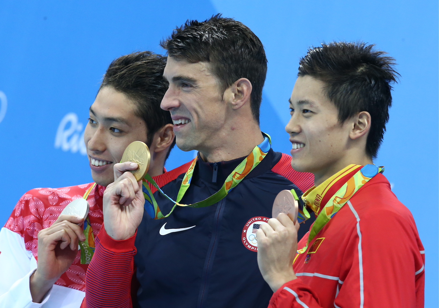 Michael Phelps (center) wins another gold medal to add to his all-time record-setting tally.