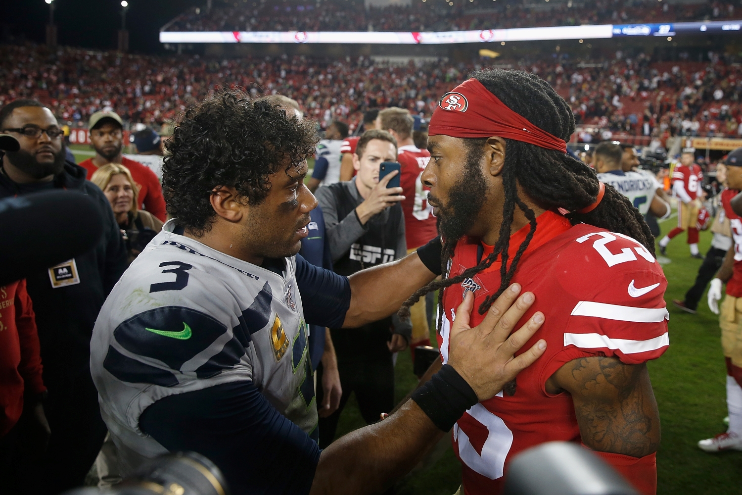 Seattle Seahawks quarterback Russell Wilson speaks to former teammate Richard Sherman after a game.