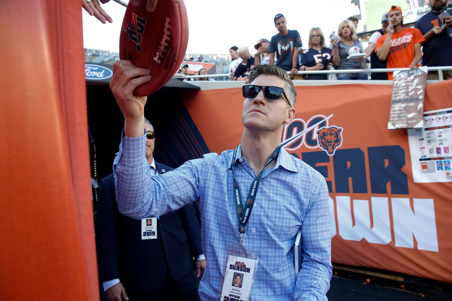 Ryan Pace hands an autographed football to a Chicago Bears fan.
