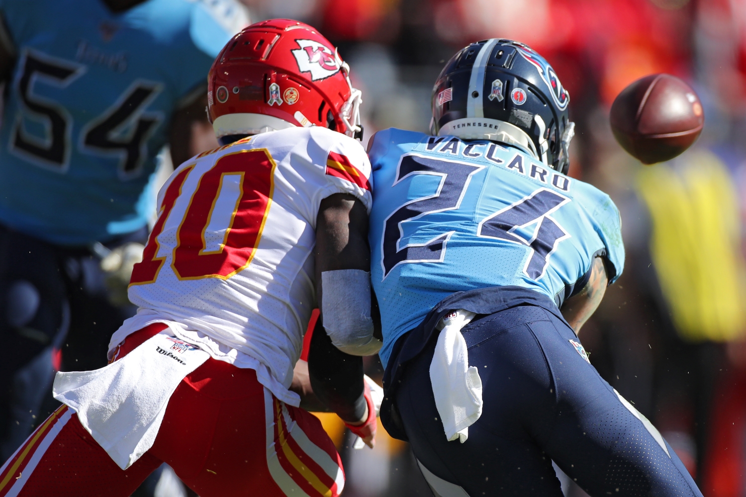 Chiefs wide receiver Tyreek Hill and Titans safety Kenny Vaccaro battle for the ball during a game.