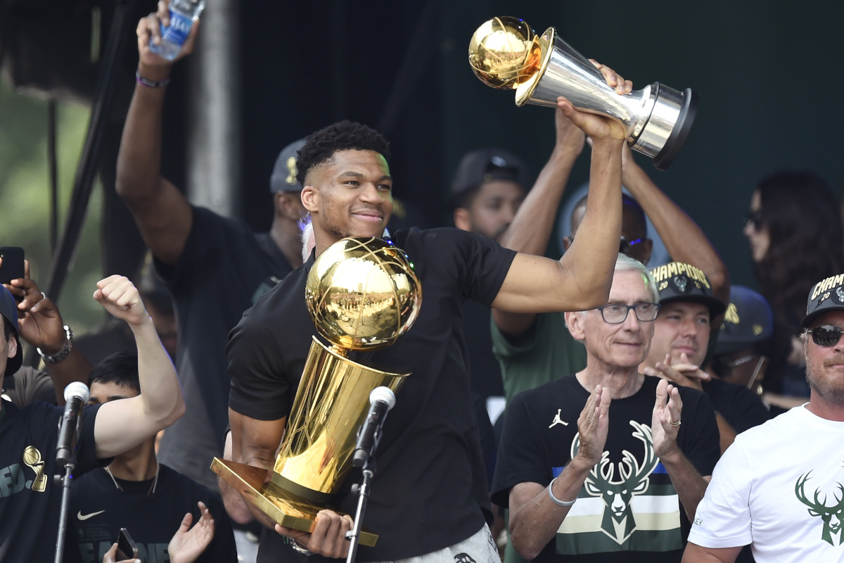 Giannis Antetokounmpo with the Larry O'Brien and Finals MVP trophies at the Milwaukee Bucks victory parade