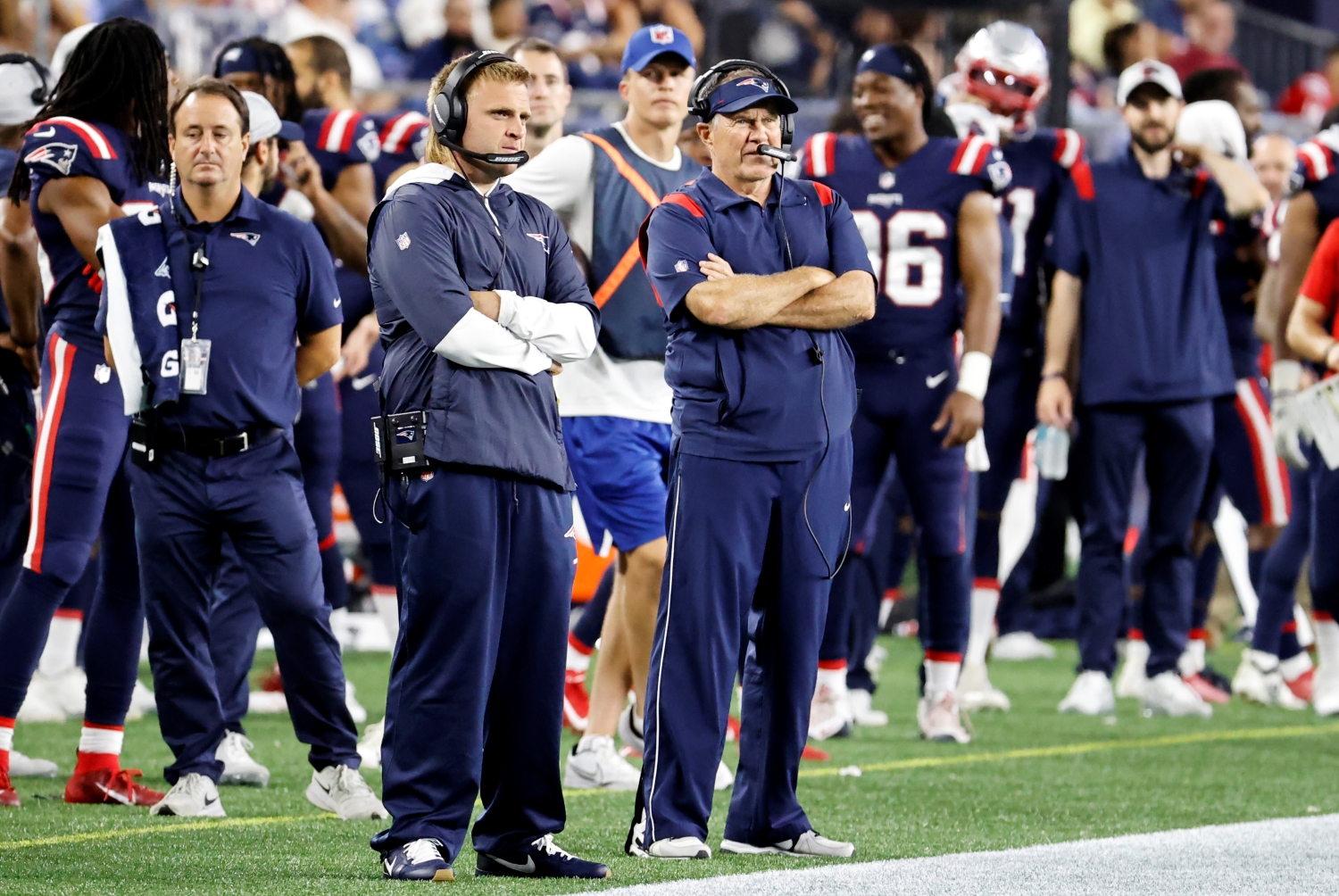 New England Patriots head coach Bill Belichick and assistant Steve Belichick watch a game from the sidelines.