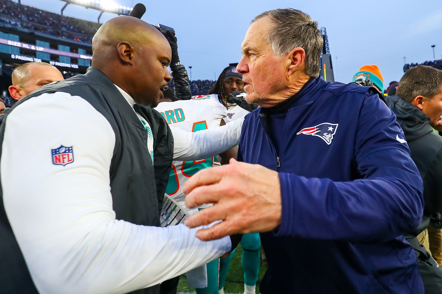 Miami Dolphins head coach Brian Flores embraces Patriots head coach Bill Belichick after a game.