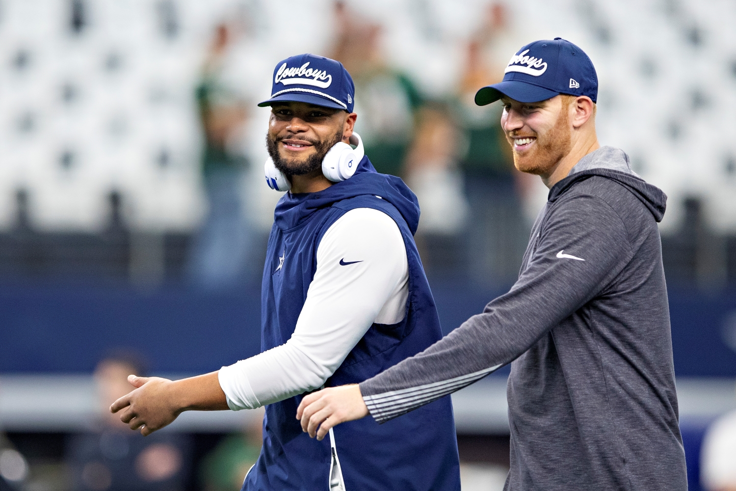 Dallas Cowboys quarterbacks Dak Prescott and Cooper Rush walk onto the field before pre-game warmups.