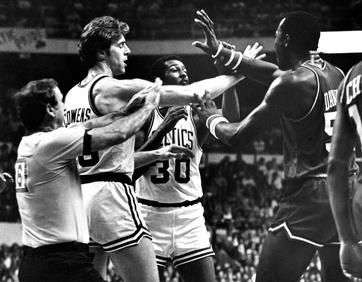 Boston Celtics' Dave Cowens and referee Walter Rooney break up the Celtics' M.L. Carr and Philadelphia's Darryl Dawkins.