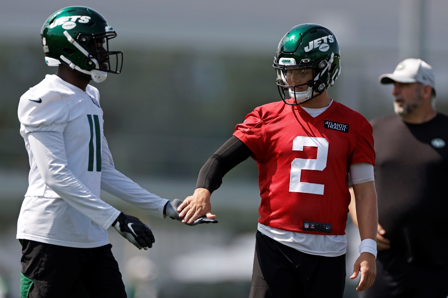 New York Jets rookie quarterback Zach Wilson shakes hands with wide receiver Denzel Mims.