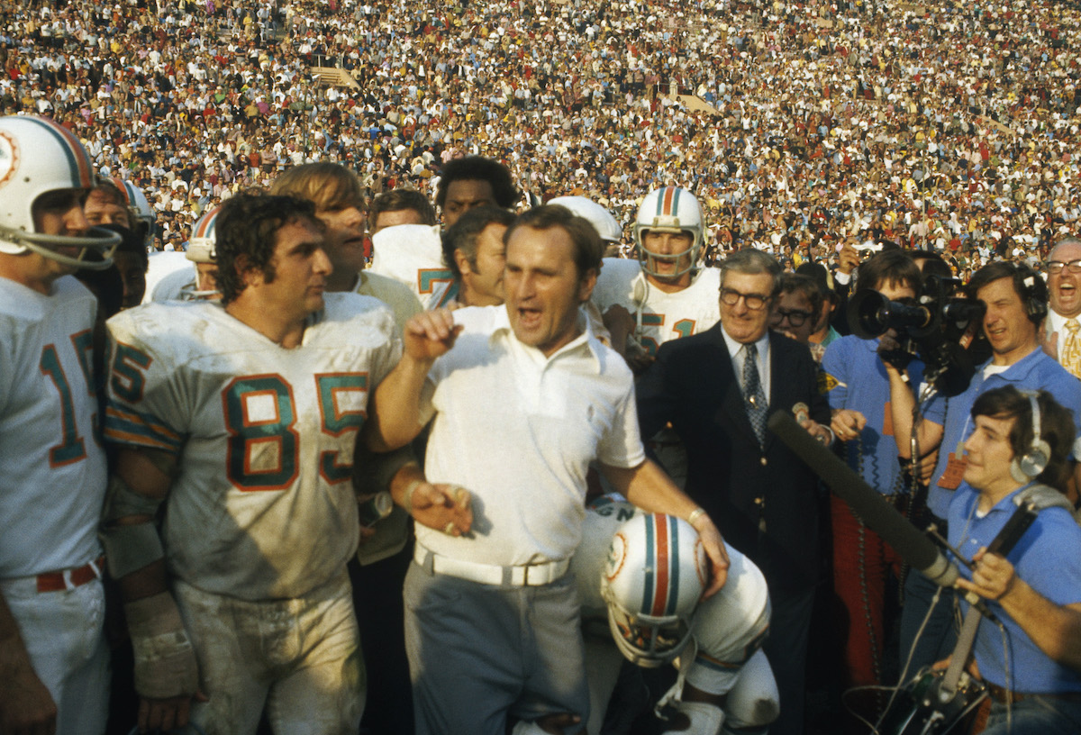 Don Shula, coach of the Miami Dolphins, talks to reporters while surrounded by his team on the field during Super Bowl VIII