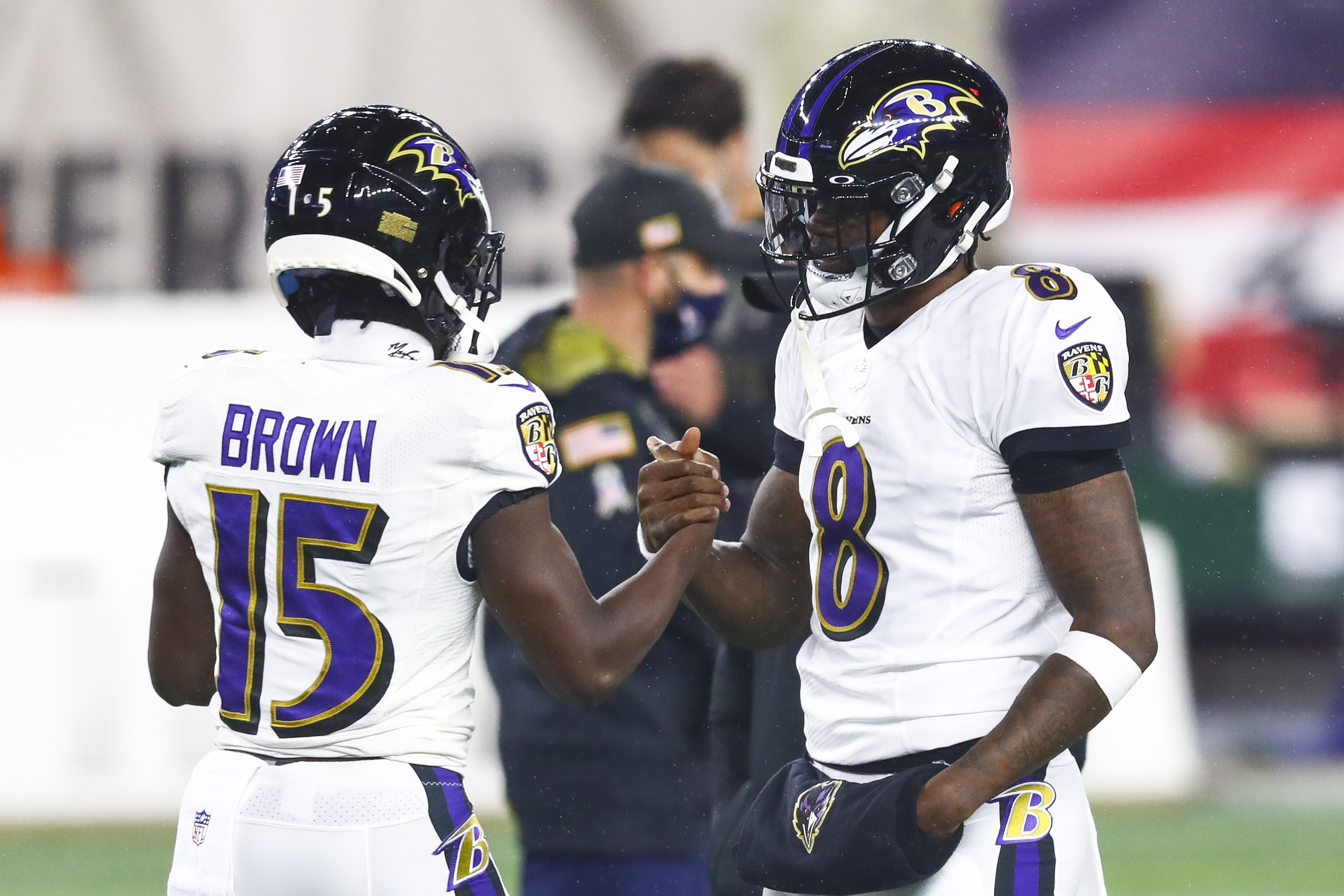 Baltimore Ravens' quarterback Lamar Jackson shakes hands with wide receiver Marquise Brown before a 2020 game against the New England Patriots. 