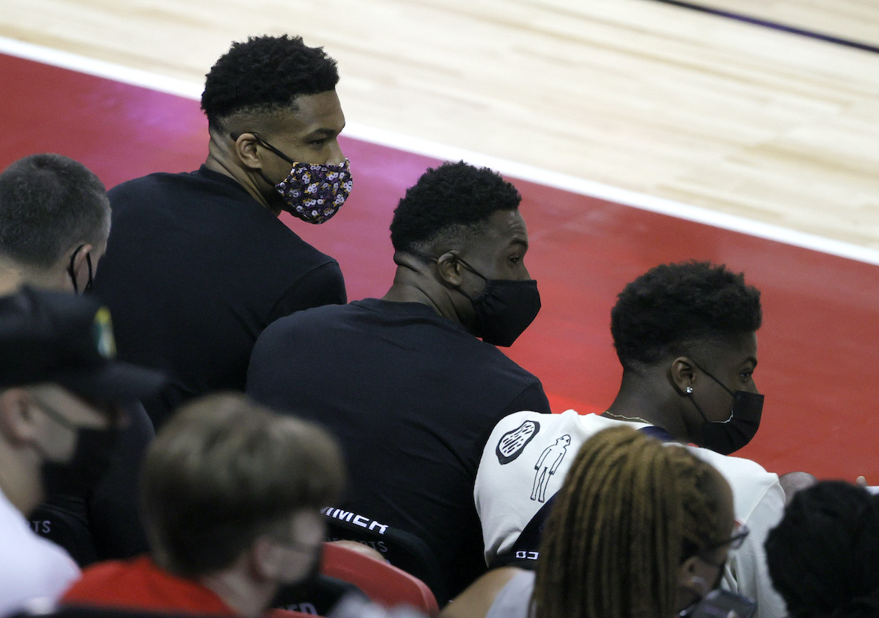 (L-R) Giannis Antetokounmpo, Thanasis Antetokounmpo , and Kostas Antetokounmpo of the Los Angeles Lakers attend a game between the Bucks and the Minnesota Timberwolves during the 2021 NBA Summer League where their brother Alex Antetokounmpo won the title.