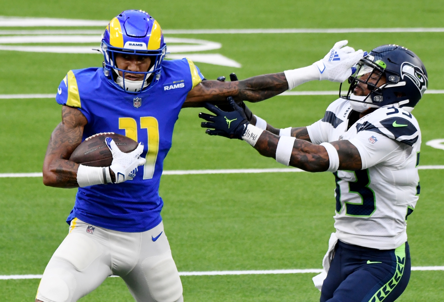 Los Angeles Rams receiver Josh Reynolds stiff arms Seattle Seahawks safety Jamal Adams during a tackle attempt.