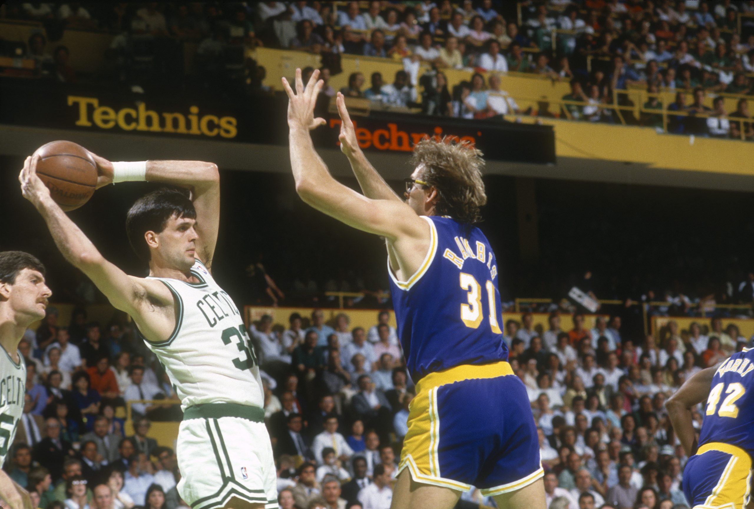 Kevin McHales looks to pass as he's guarded by Kurt Rambis of the Los Angeles Lakers.