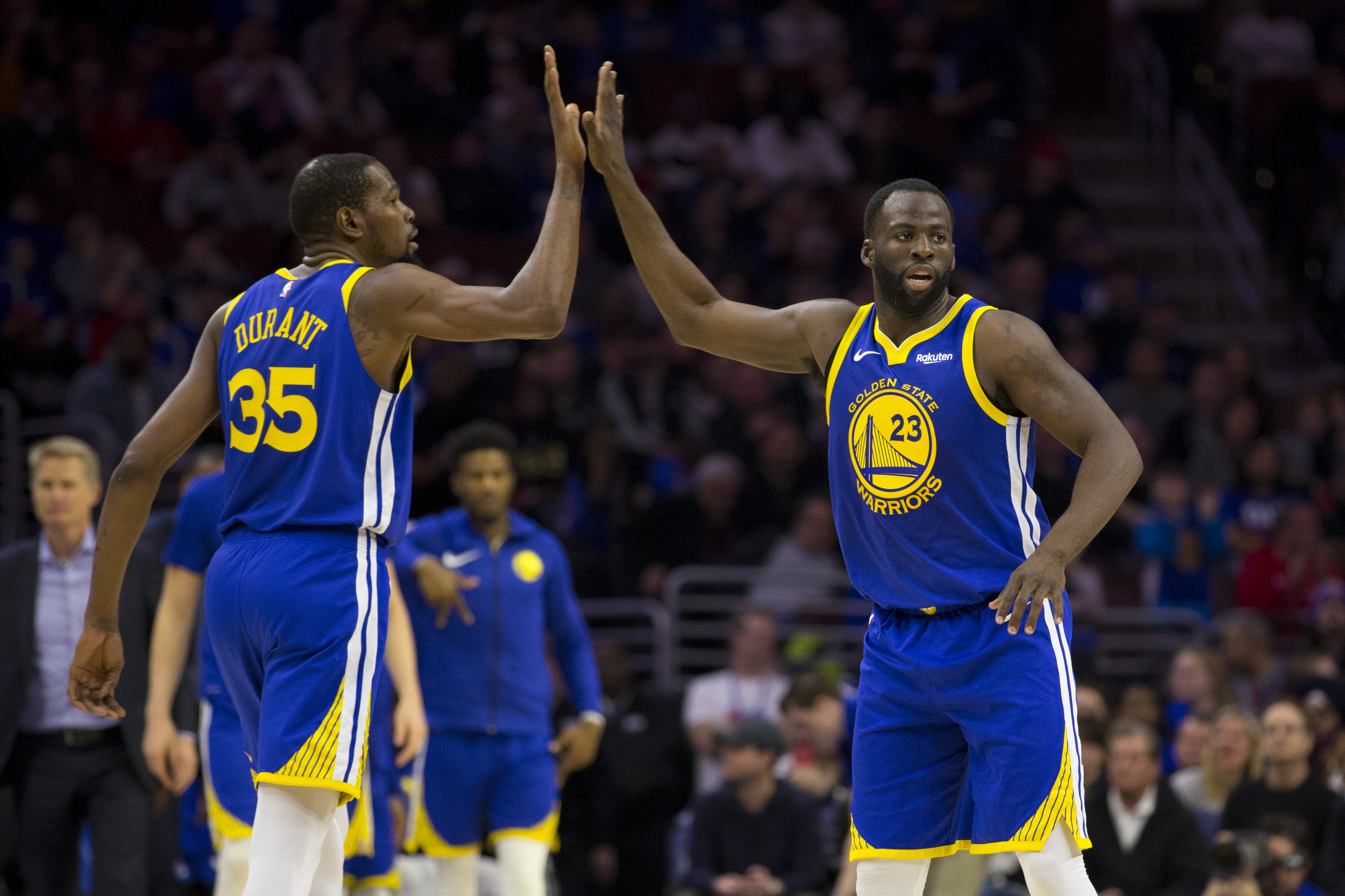 Kevin Durant and Draymond Green high five during Golden State Warriors basketball game