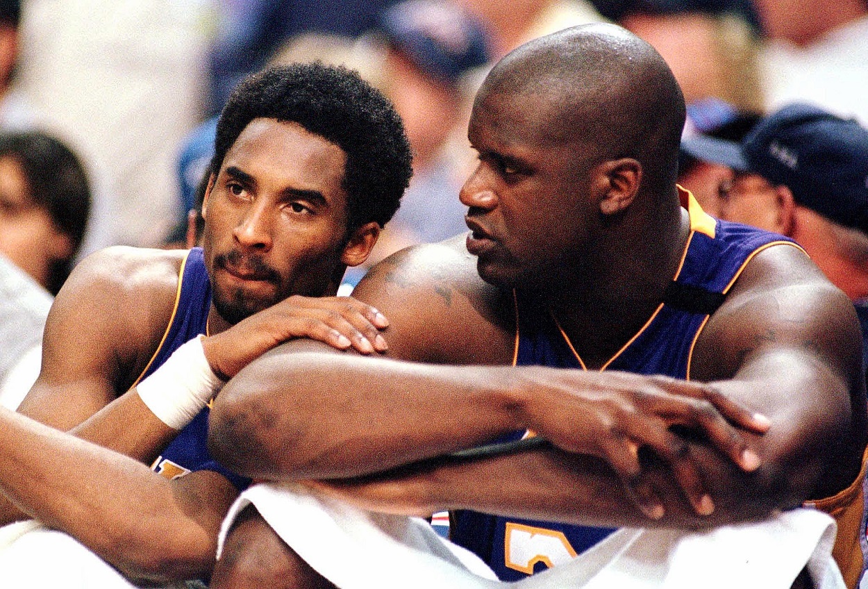 Former Lakers Kobe Bryant and Shaquille O'Neal sit on the bench during an NBA game.