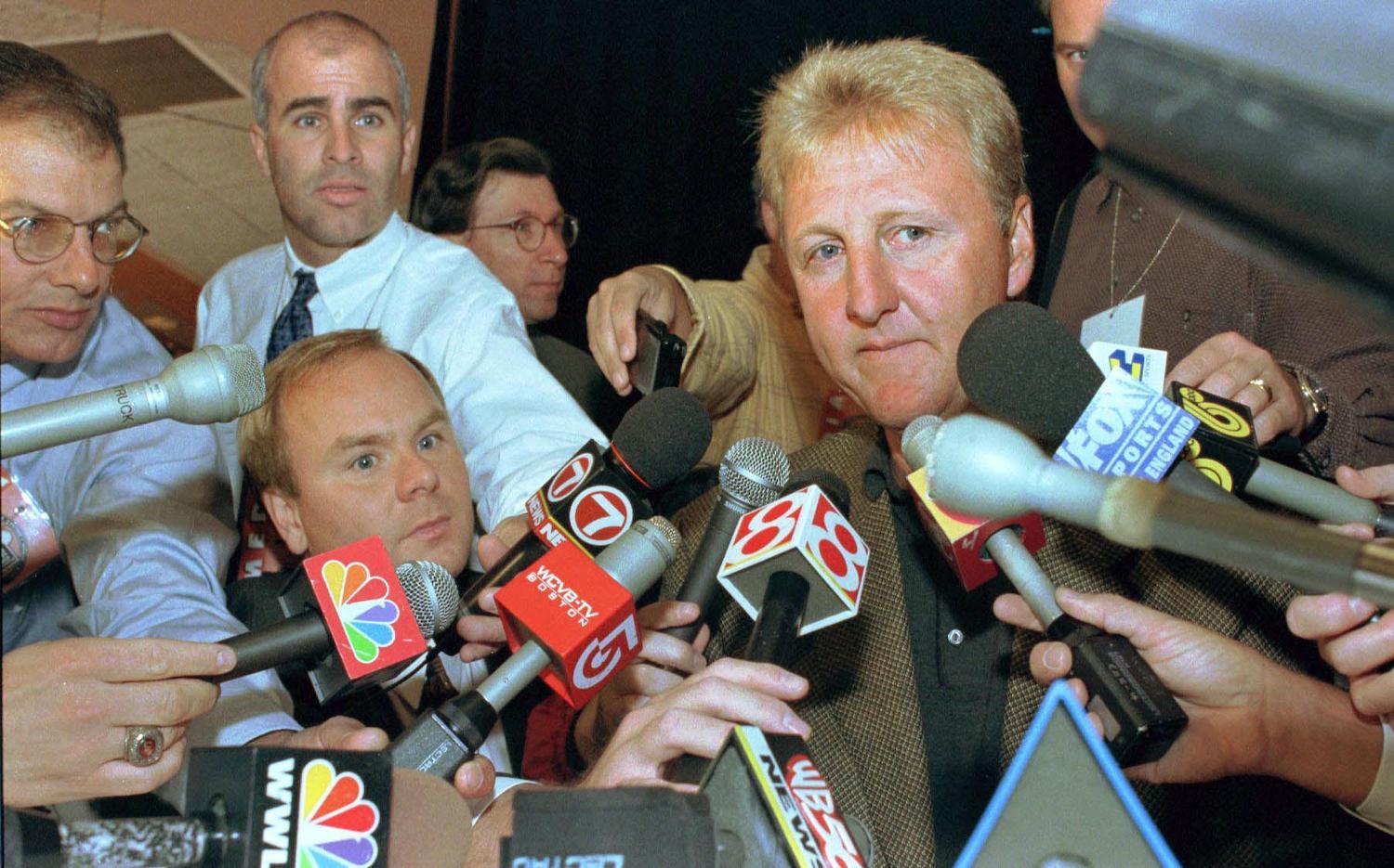 Larry Bird is surrounded by media during 1998.