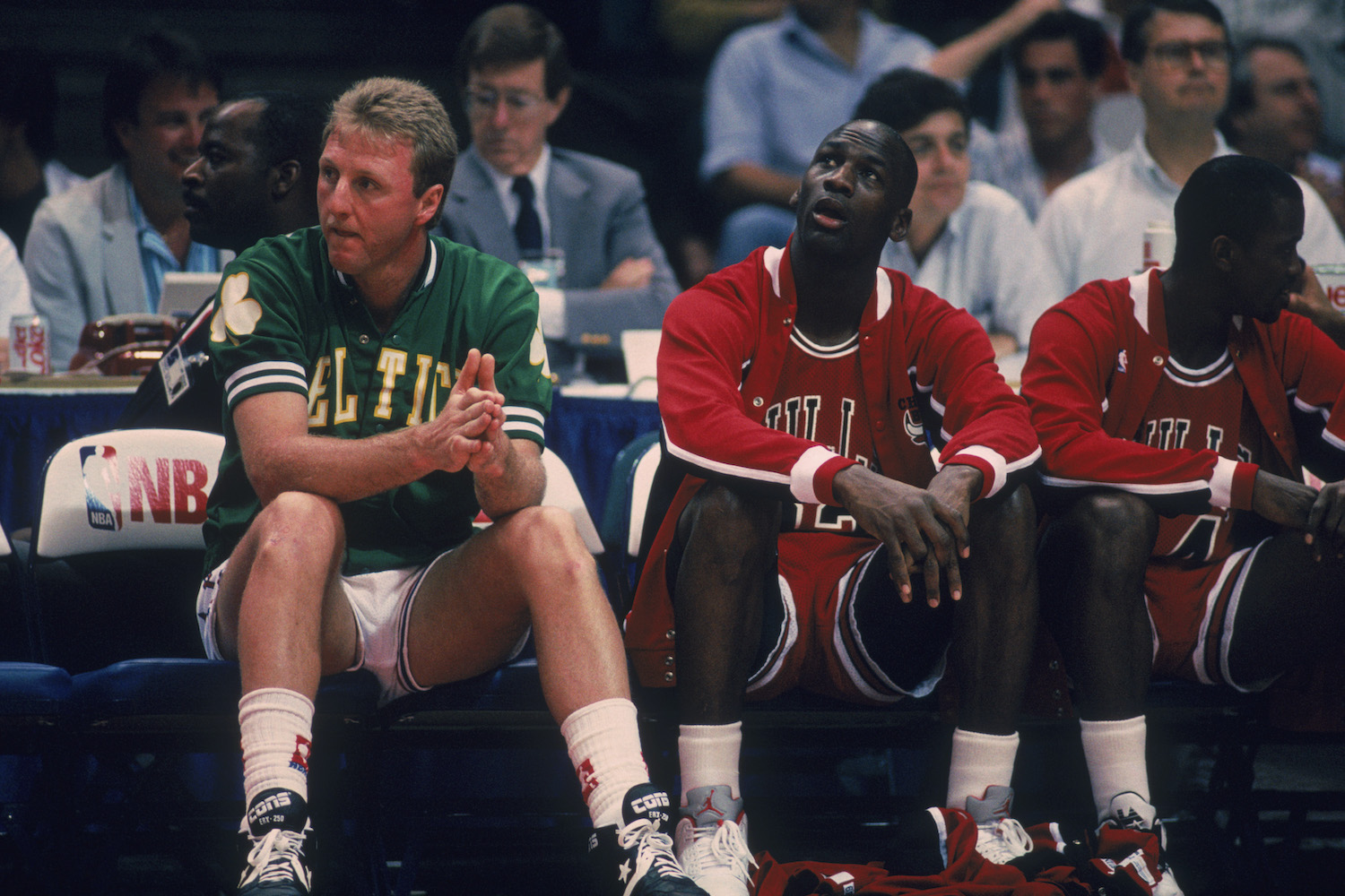 NBA stars Larry Bird and Michael Jordan sit together on the bench.