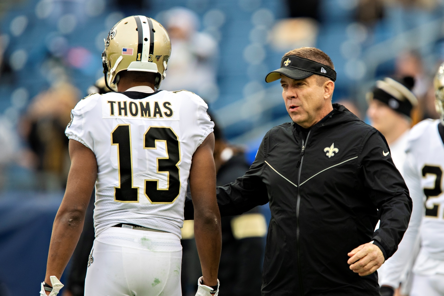 New Orleans Saints head coach speaks to wide receiver Michael Thomas as he walks toward the sideline.