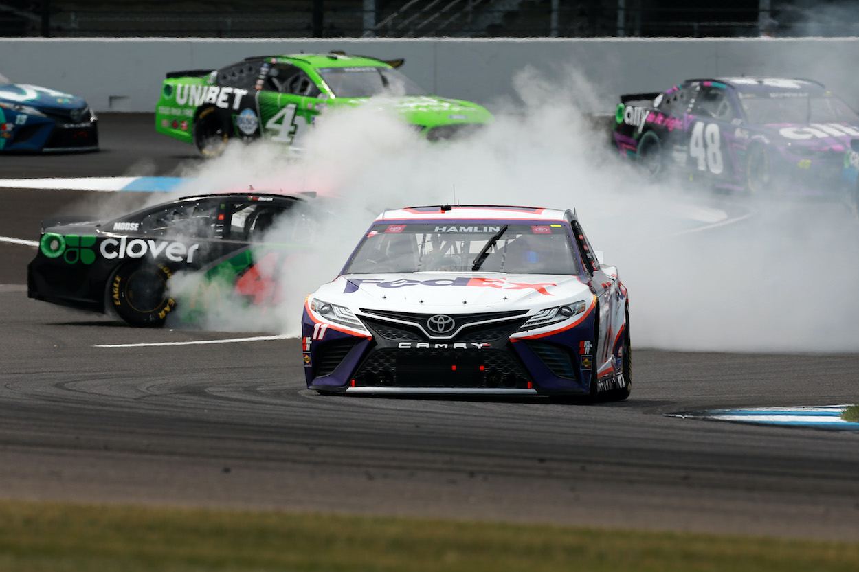 Denny Hamlin drives as Ross Chastain spins behind him
