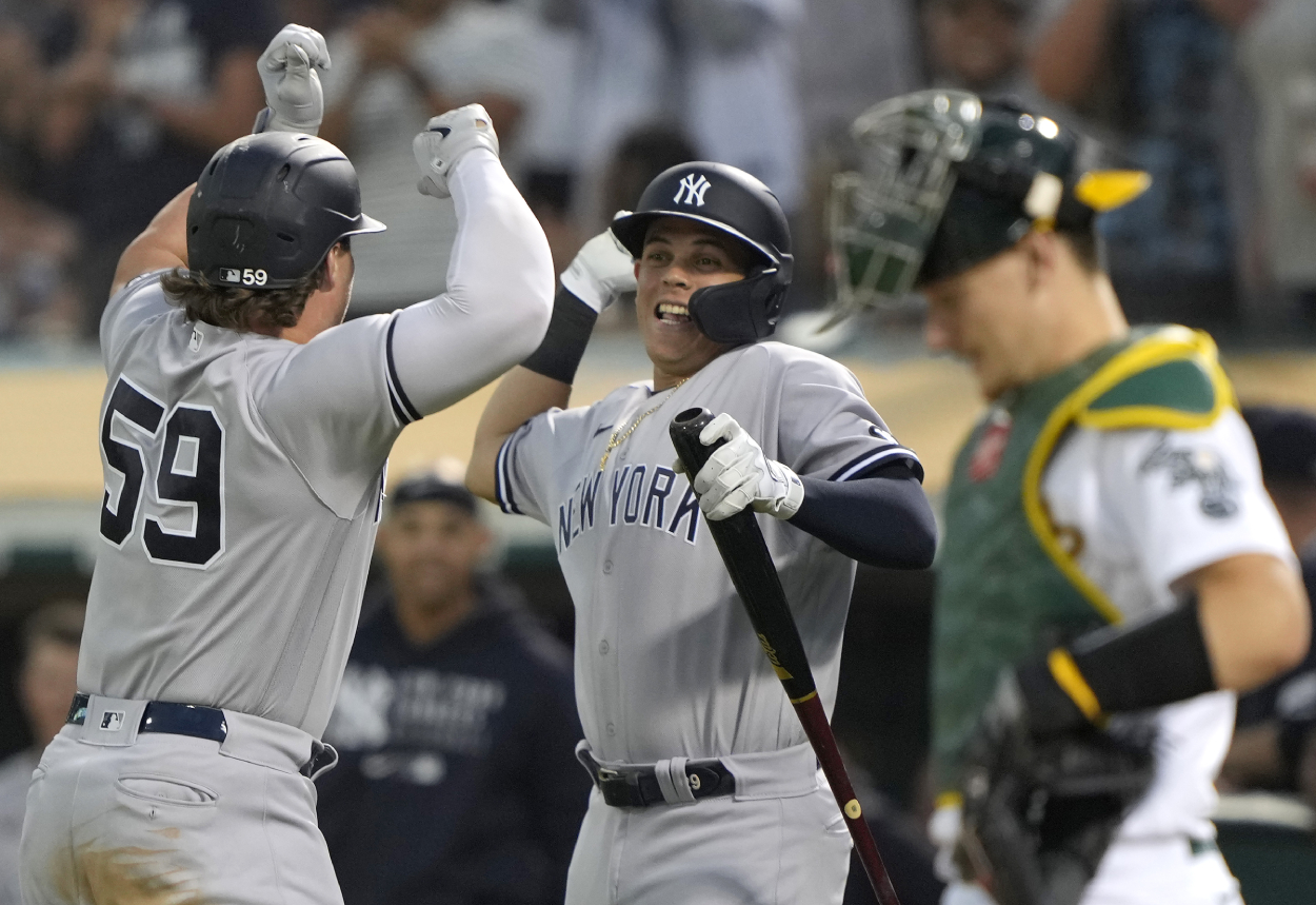 Luke Voit #59 and Gio Urshela #29 of the New York Yankees celebrate after Voit hit a solo home run against the Oakland Athletics.
