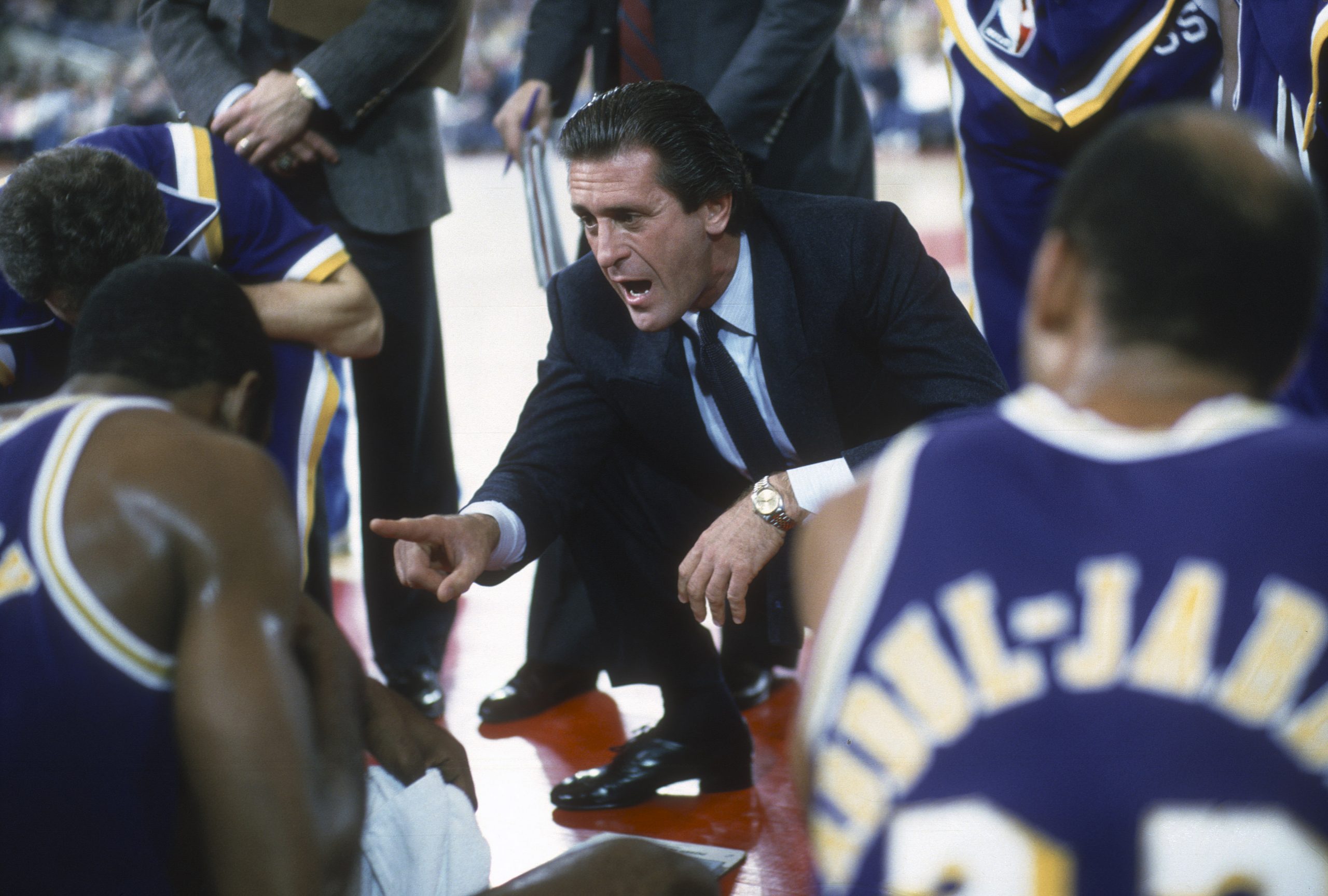 Head Coach Pat Riley of the Los Angeles Lakers talks with his team while there's a time out during an NBA basketball game circa 1985.