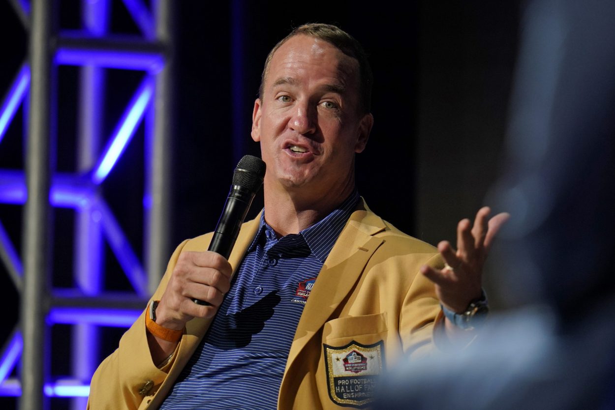 Wearing a yellow jacket, Peyton Manning speaks to the audience at the Pro Football Hall of Fame