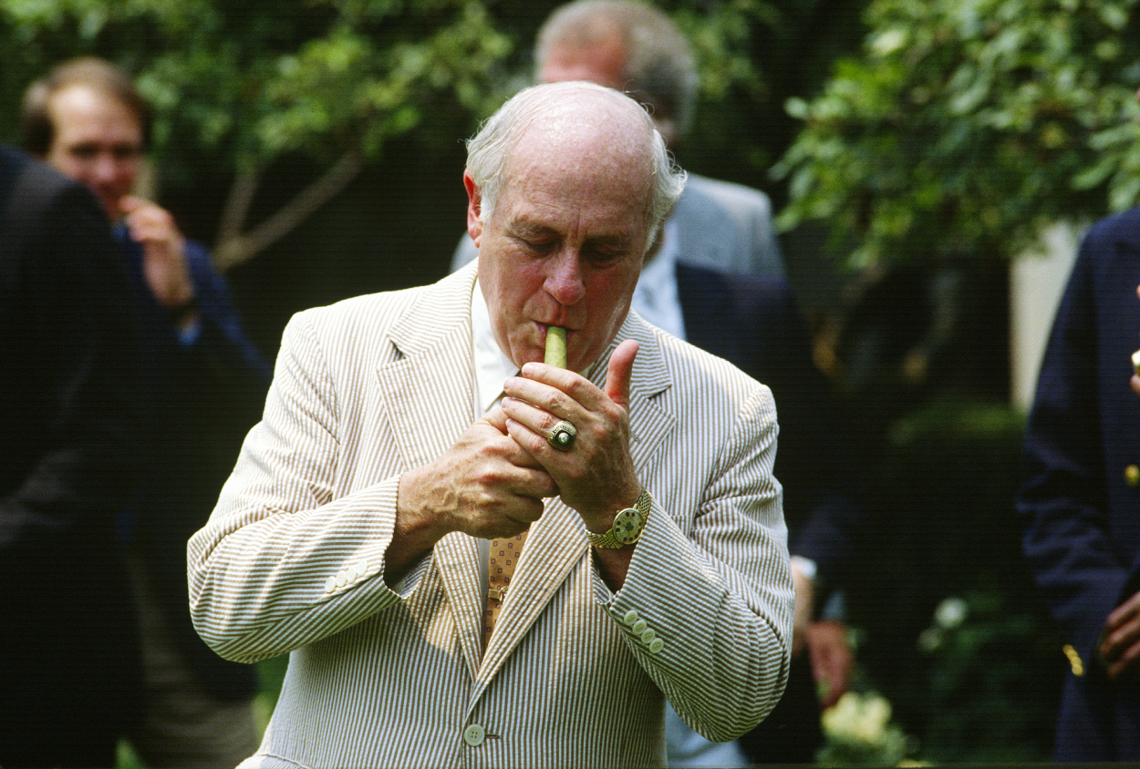 General Manager Red Auerbach and the NBA Champions Boston Celtics lights a cigar.