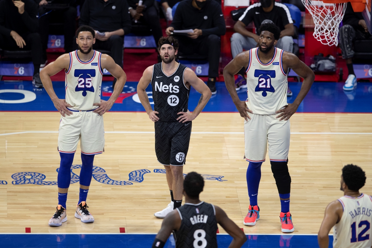 Joel Embiid and Ben Simmons of the Philadelphia 76ers await a free throw during a game against the Brooklyn Nets.