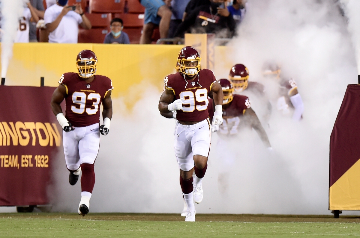 Chase Young and Jonathan Allen of the Washington Football Team defense run onto the field before the NFL preseason game against the Cincinnati Bengals.