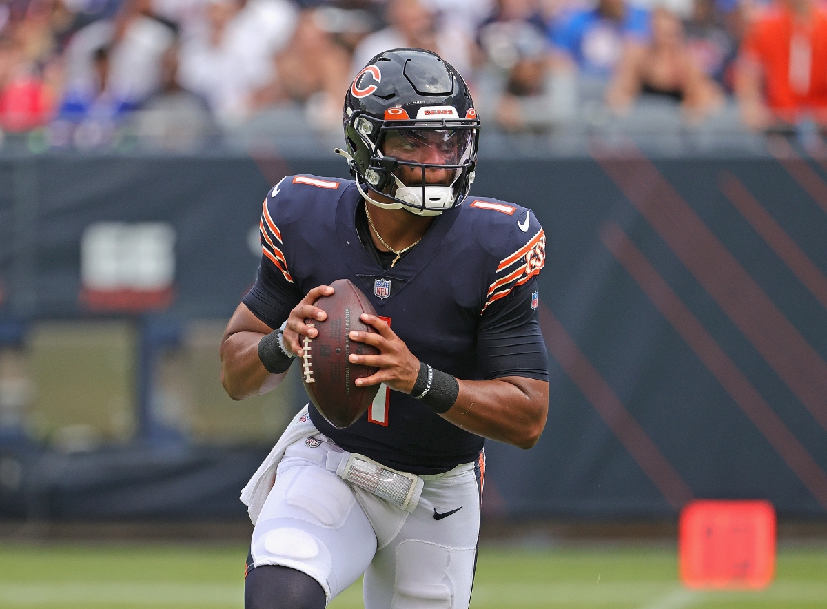 Justin Fields of the Chicago Bears rolls out to throw a pass during a preseason game.