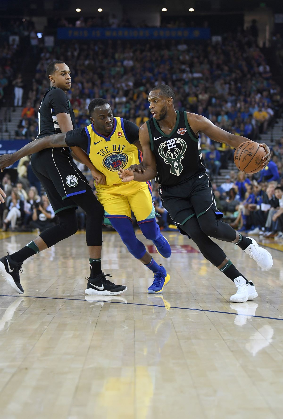 The Milwaukee Bucks' Khris Middleton is guarded by Draymond Green of the Golden State Warriors.