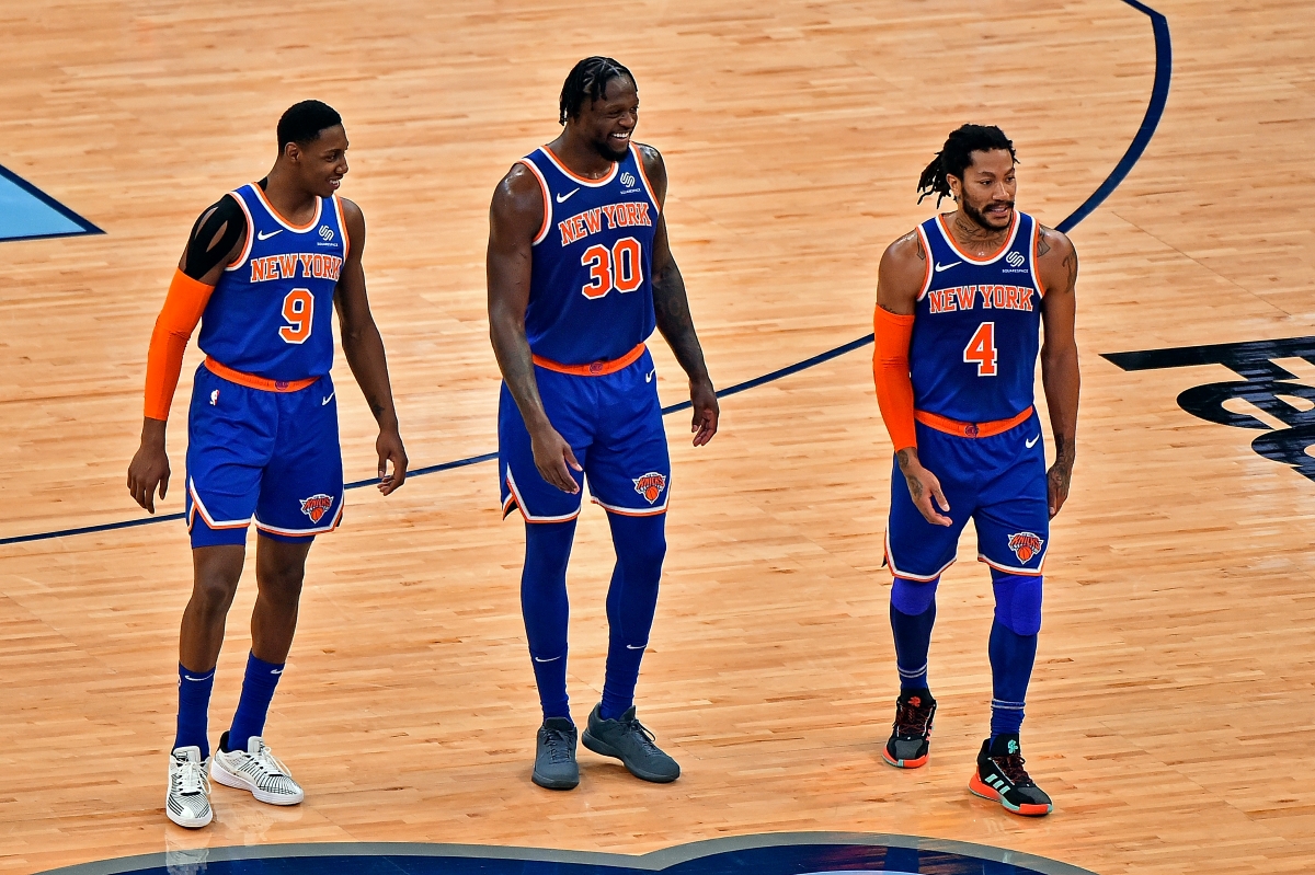 The New York Knicks' RJ Barrett, Julius Randle, and Derrick Rose walk onto the floor in Madison Square Garden.