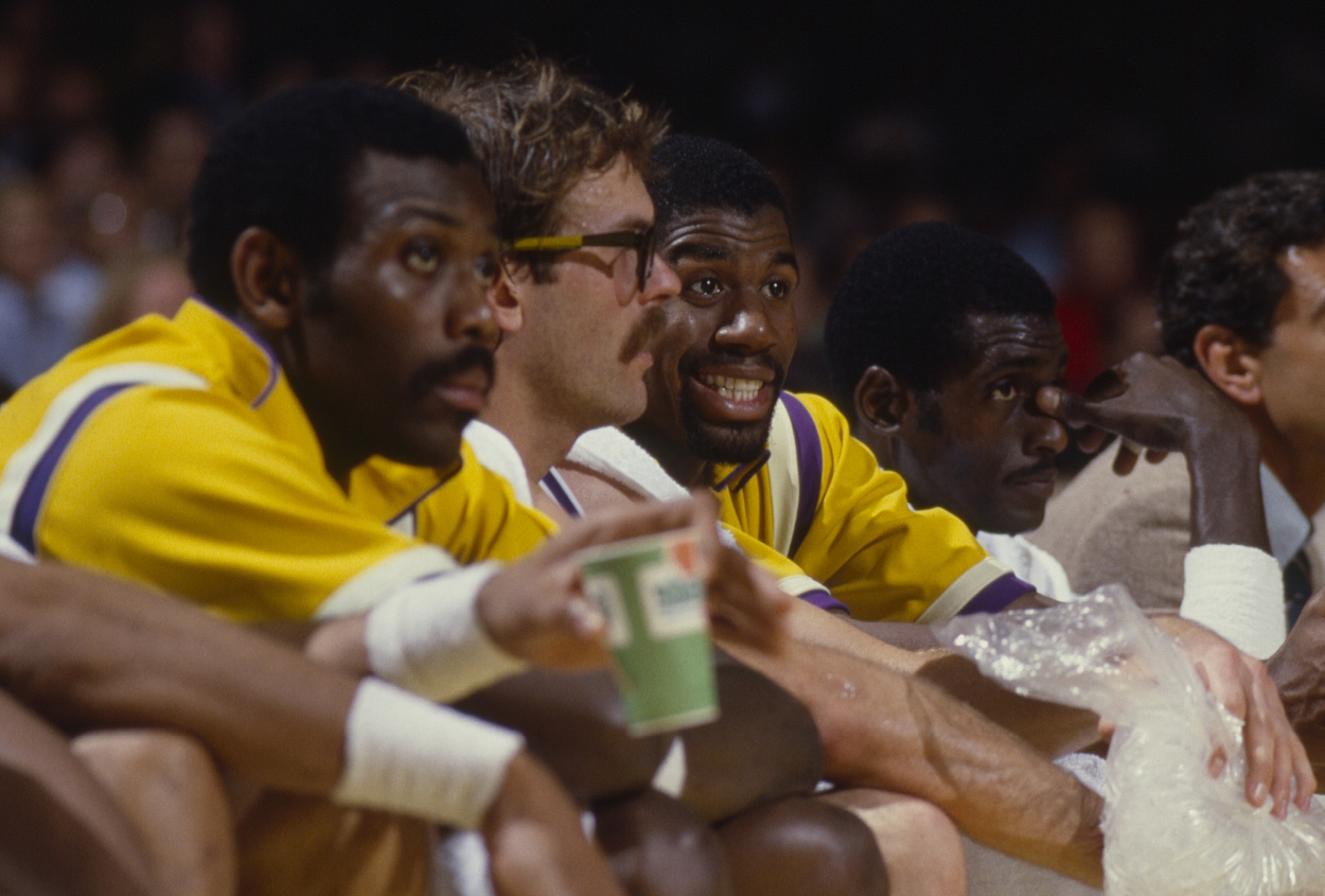Los Angeles Lakers Magic Johnson talks with Kurt Rambis on bench during 1985 NBA Finals.