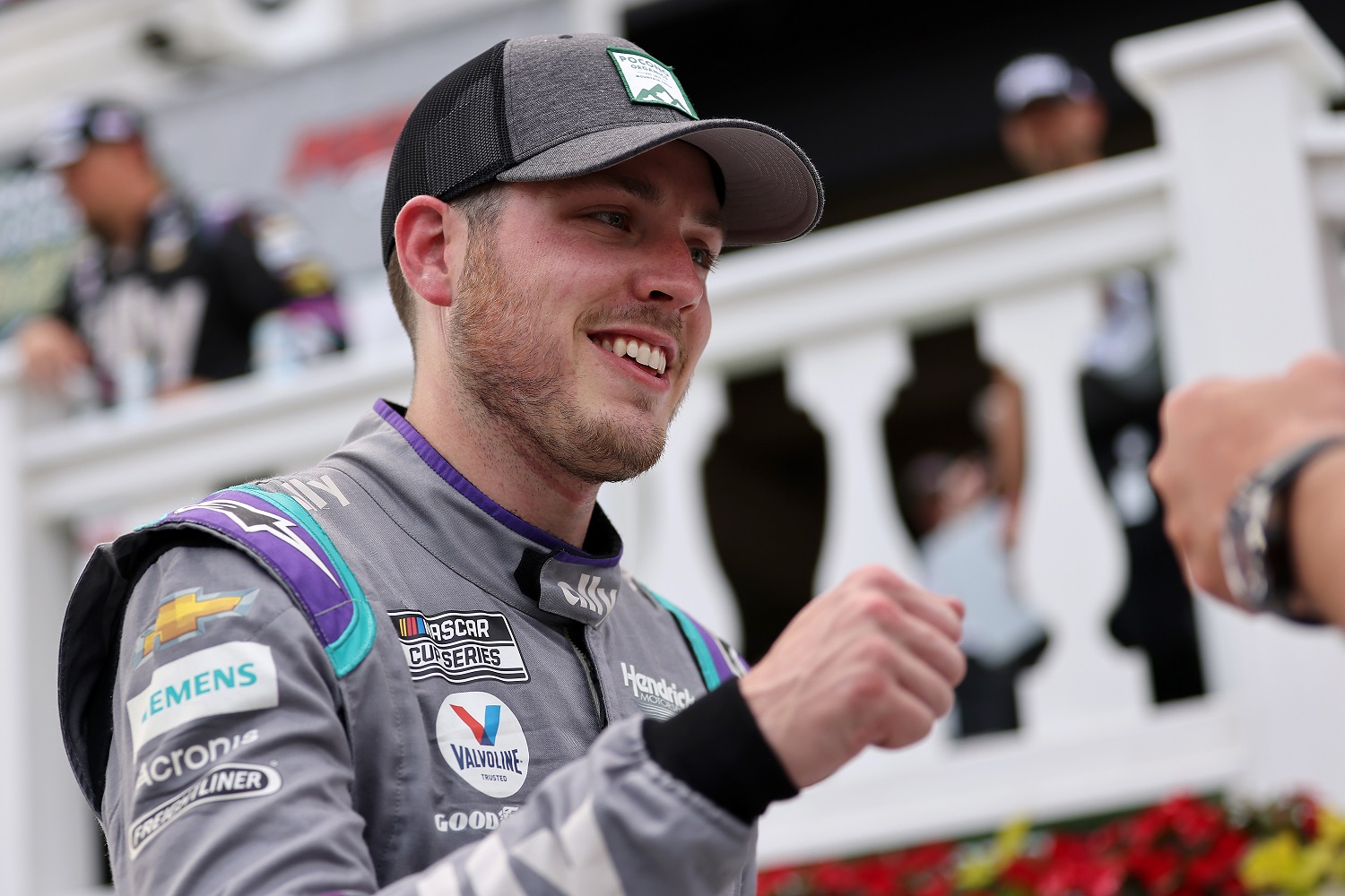 Alex Bowman, driver of the No. 48 Chevrolet, gives a fist bump in victory lane after winning the NASCAR Cup Series Pocono Organics CBD 325 on June 26, 2021.