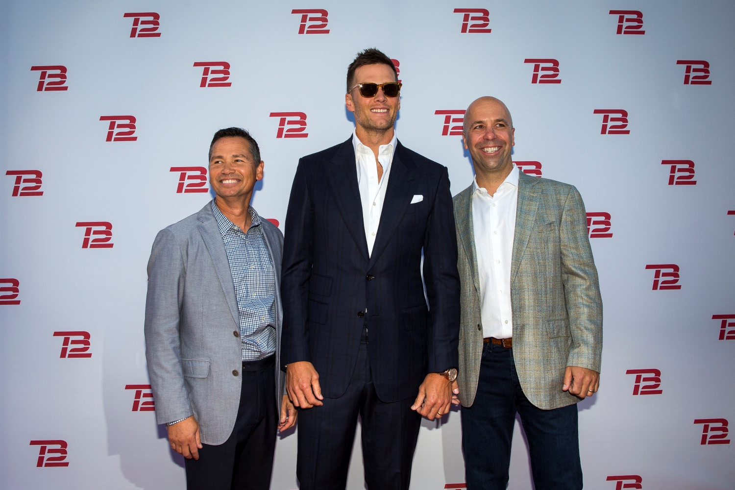 Alex Guerrero stands with Tom Brady and TB12 CEO John Burns during the TB12 Grand Opening Event at the TB12 Performance & Recovery Center in Boston.