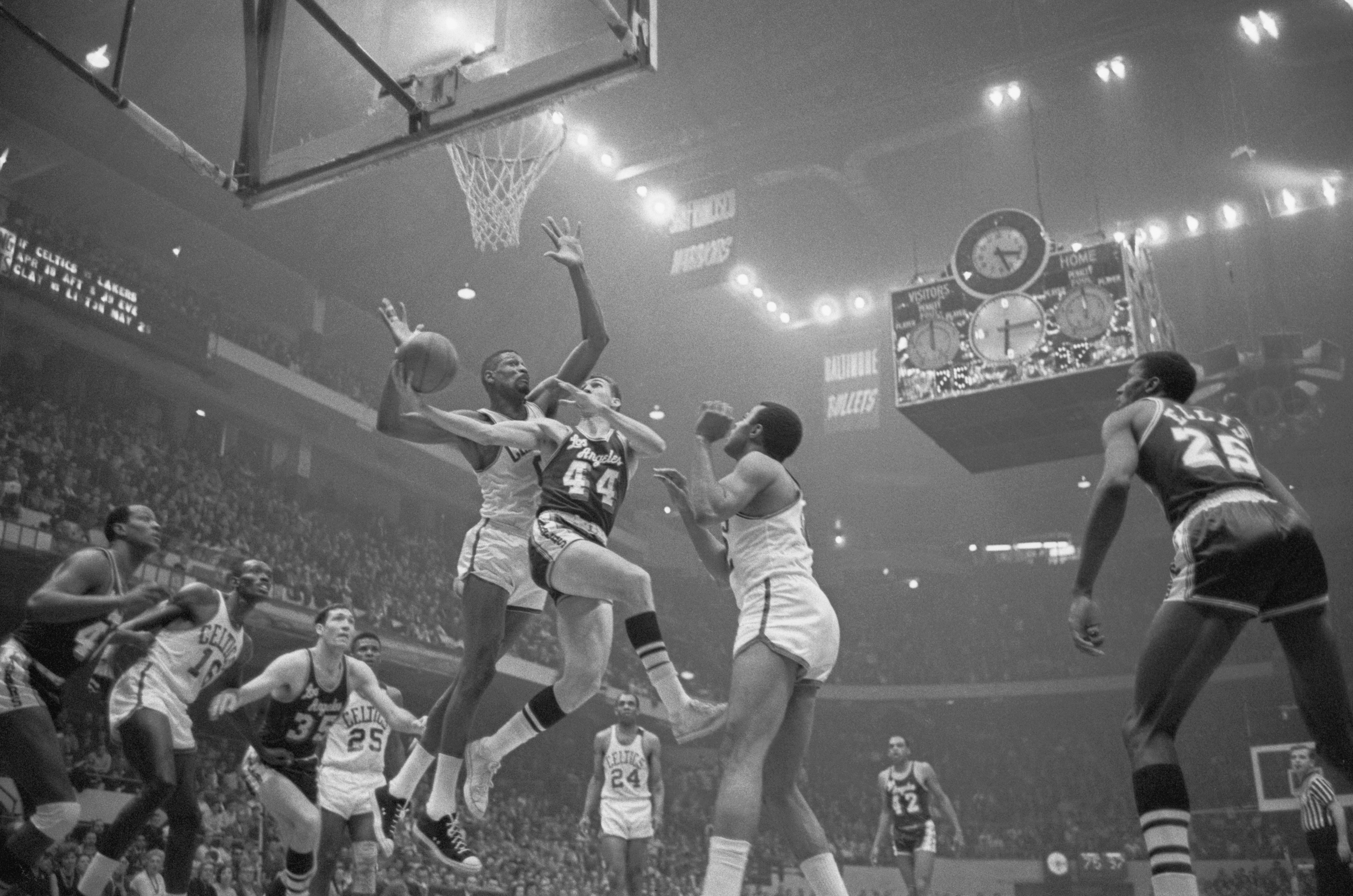 Bill Russell tries to block Jerry West's shot during a game between the Celtics and Lakers