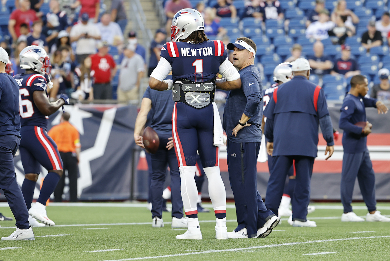 New England Patriots offensive coordinator Josh McDaniels talks to New England Patriots quarterback Cam Newton, who lost his job to Mac Jones, in warm up before a preseason game between the New England Patriots and the Washington Football Team on August 12, 2021, at Gillette Stadium in Foxborough, Massachusetts.